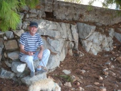 an elderly resident rests on the step after walking his dog